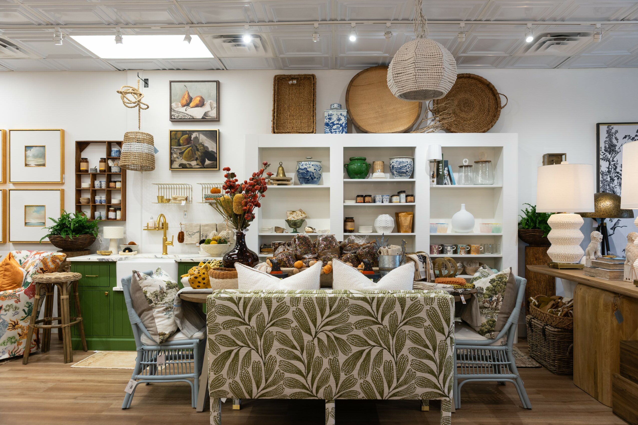 Living room with white shelves, decorative items, a floral sofa, and various furniture pieces.
