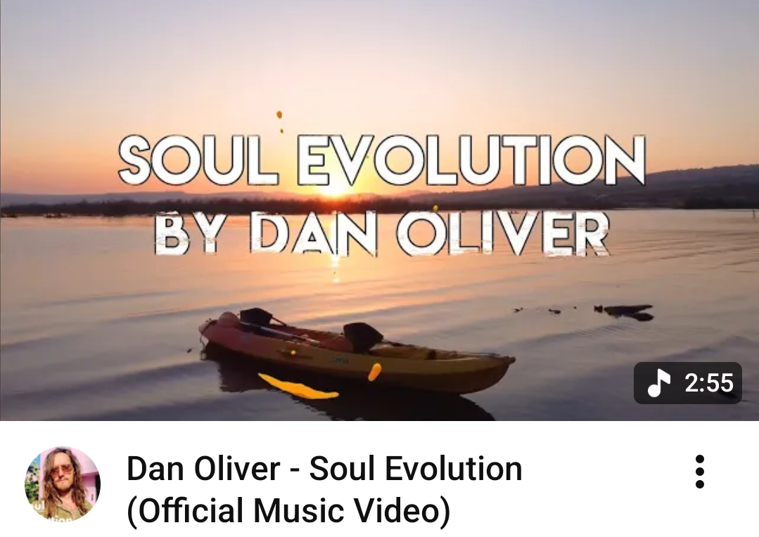 Sunset over a lake with a kayak floating on calm water, and text overlay reading 'Soul Evolution by Dan Oliver'.