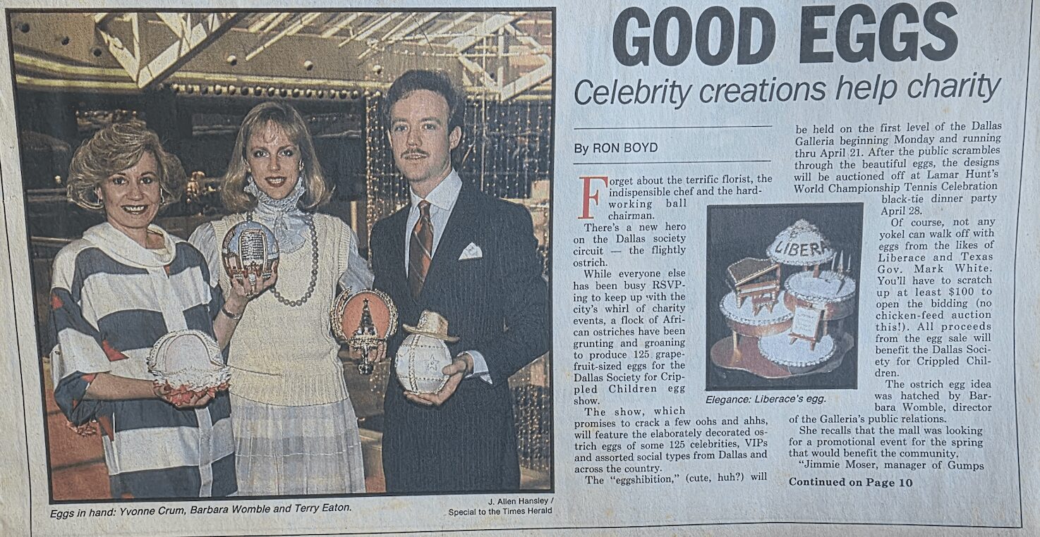 Three people holding eggs and a basket, standing indoors with a sign reading 'Good Eggs' in the background.