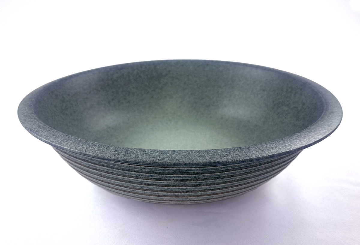 Gray ceramic bowl with textured exterior and smooth interior, placed on a white surface.