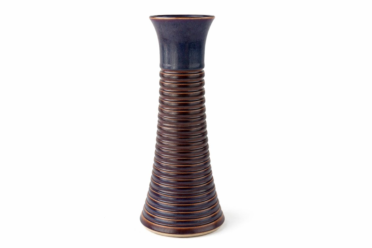 Tall, ribbed ceramic vase with a narrow opening and a dark blue top, brown body with horizontal stripes.