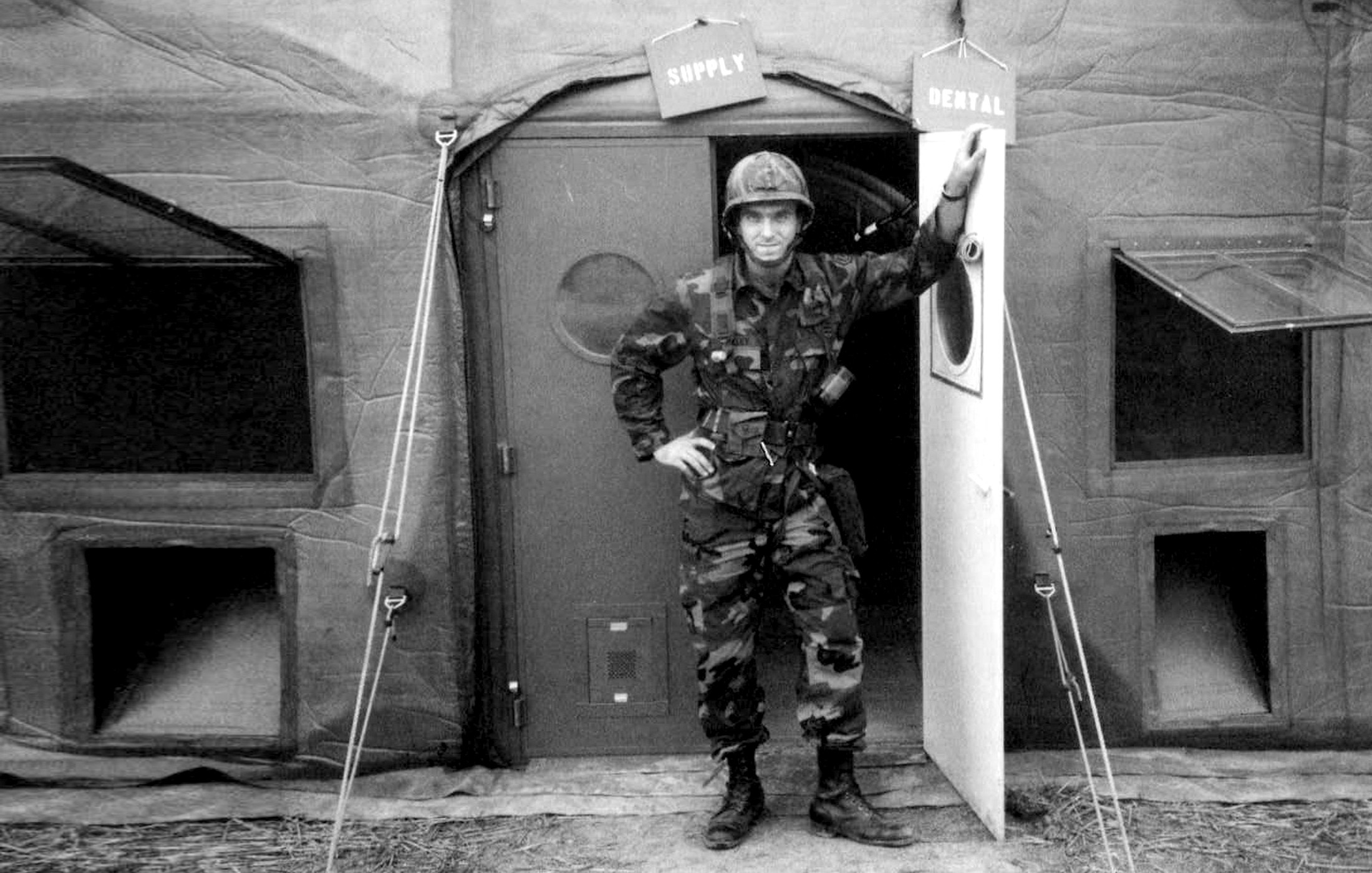 Soldier standing in a doorway labeled 'REHAB' with two signs above, one reading 'REHAB' and the other 'RELEASE'.