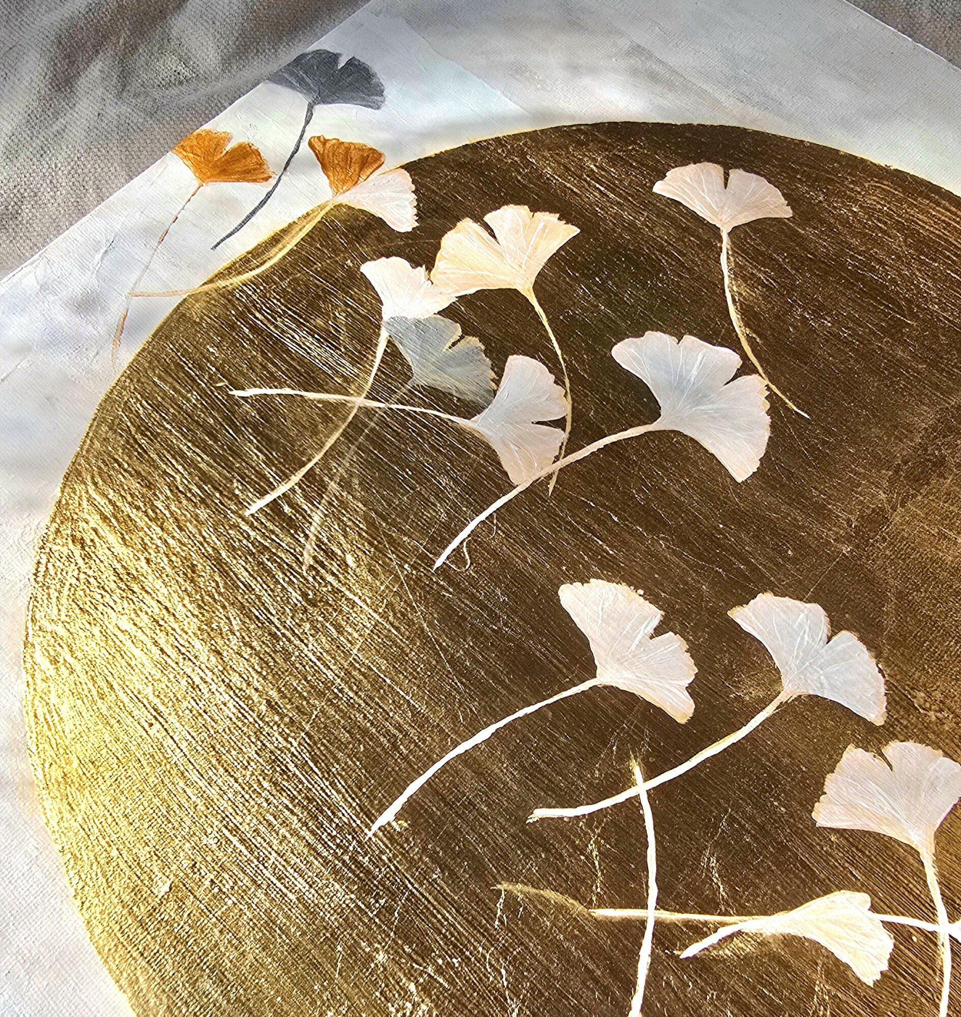 Decorative surface with white and orange ginkgo leaf patterns on a dark background.