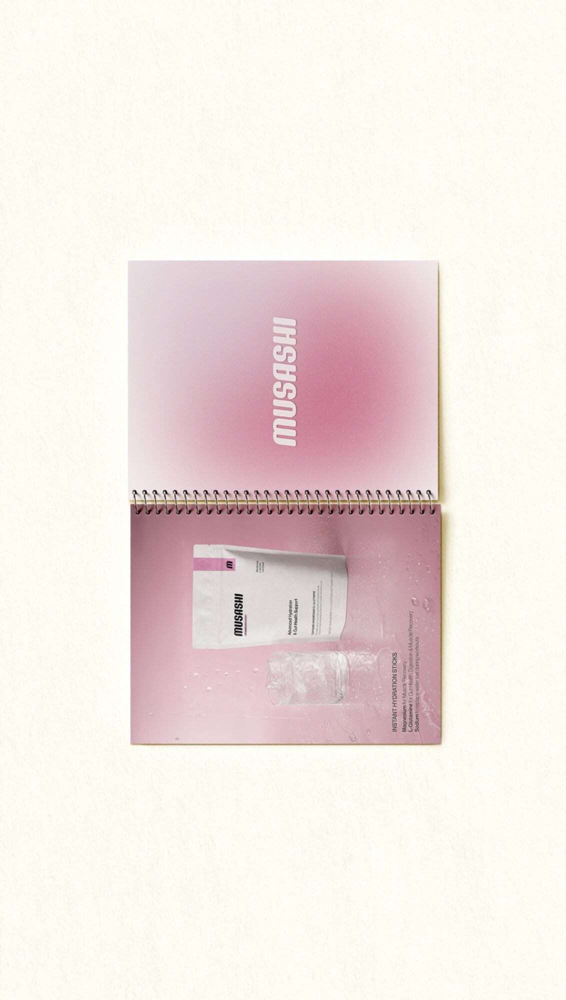 Open pink box with the word 'MUSUBI' on the inside lid, containing a white package and pink background.