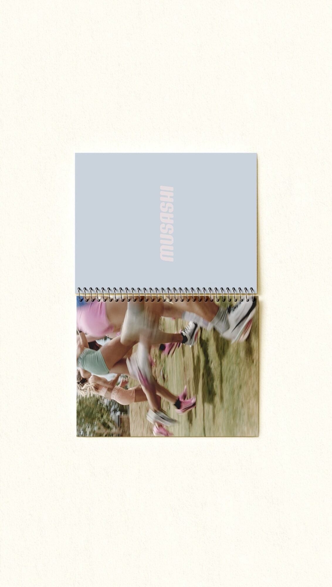 A book with a light blue cover and a spiral binding, partially open, showing a colorful illustration inside.