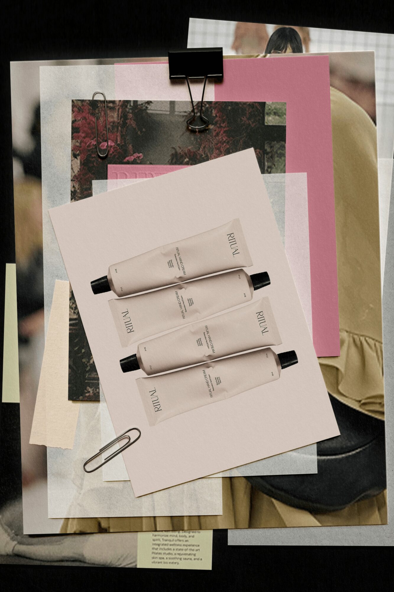 A collection of papers, photos, and three white pens clipped to a white sheet, with a paperclip attached, on a dark surface.