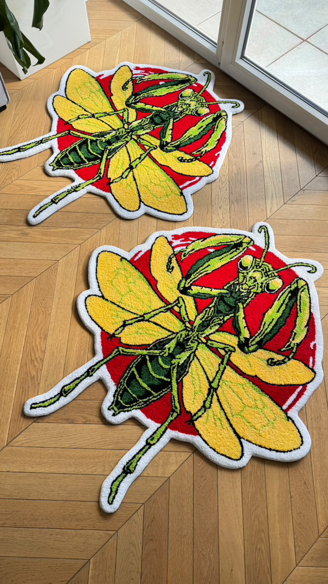 Two embroidered patches of yellow butterflies with green and black details, placed on a wooden surface near a glass door.