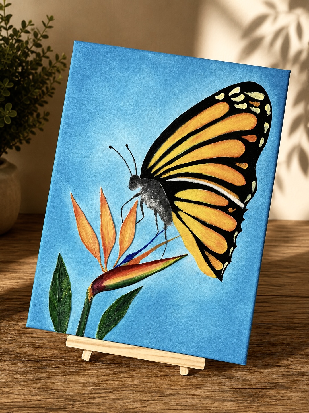 Painting of a butterfly with orange and black wings perched on orange flowers against a blue background.