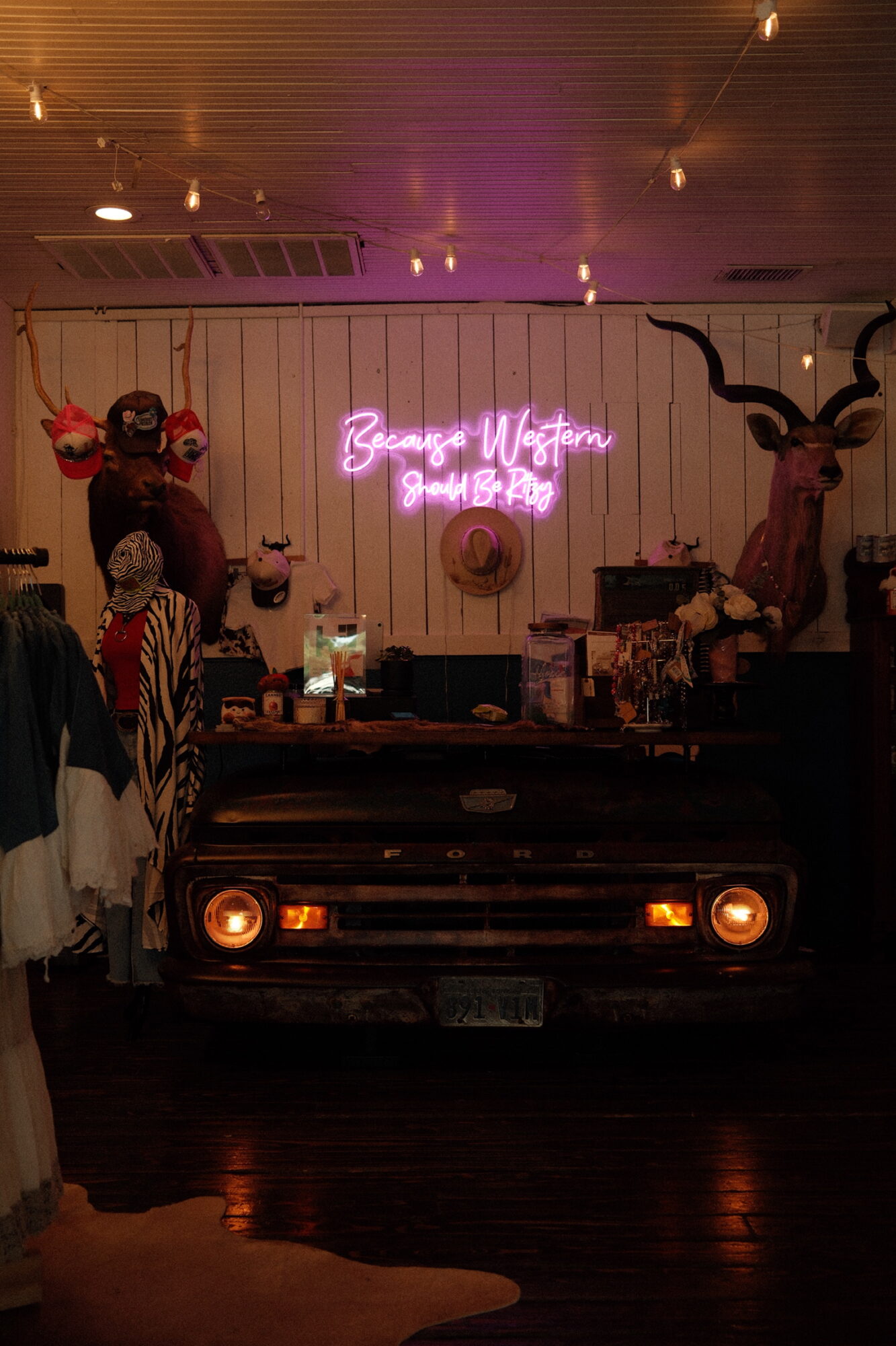 Bar with neon sign reading 'Beyonce Victory' and animal head decorations, including a deer and a zebra, on the wall.