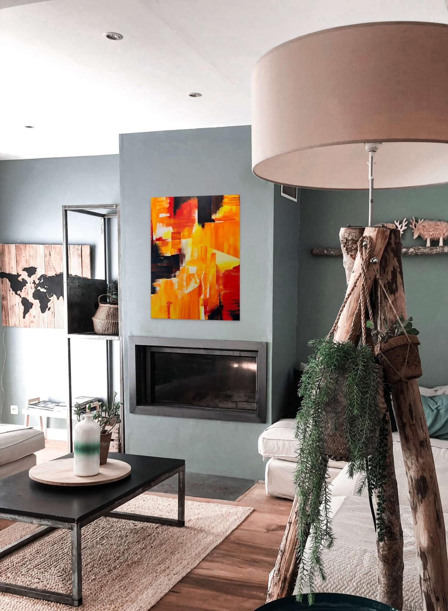 Living room with a fireplace, colorful abstract painting, large beige lampshade, and modern furniture.