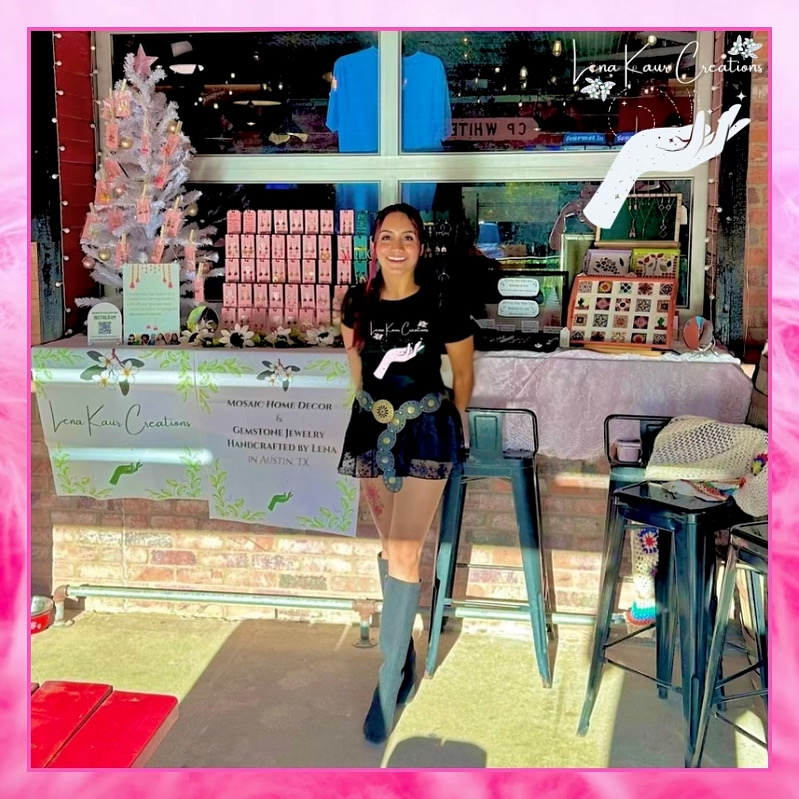 Young woman standing outside a shop with pink and white decorations, smiling, with tables and chairs nearby.