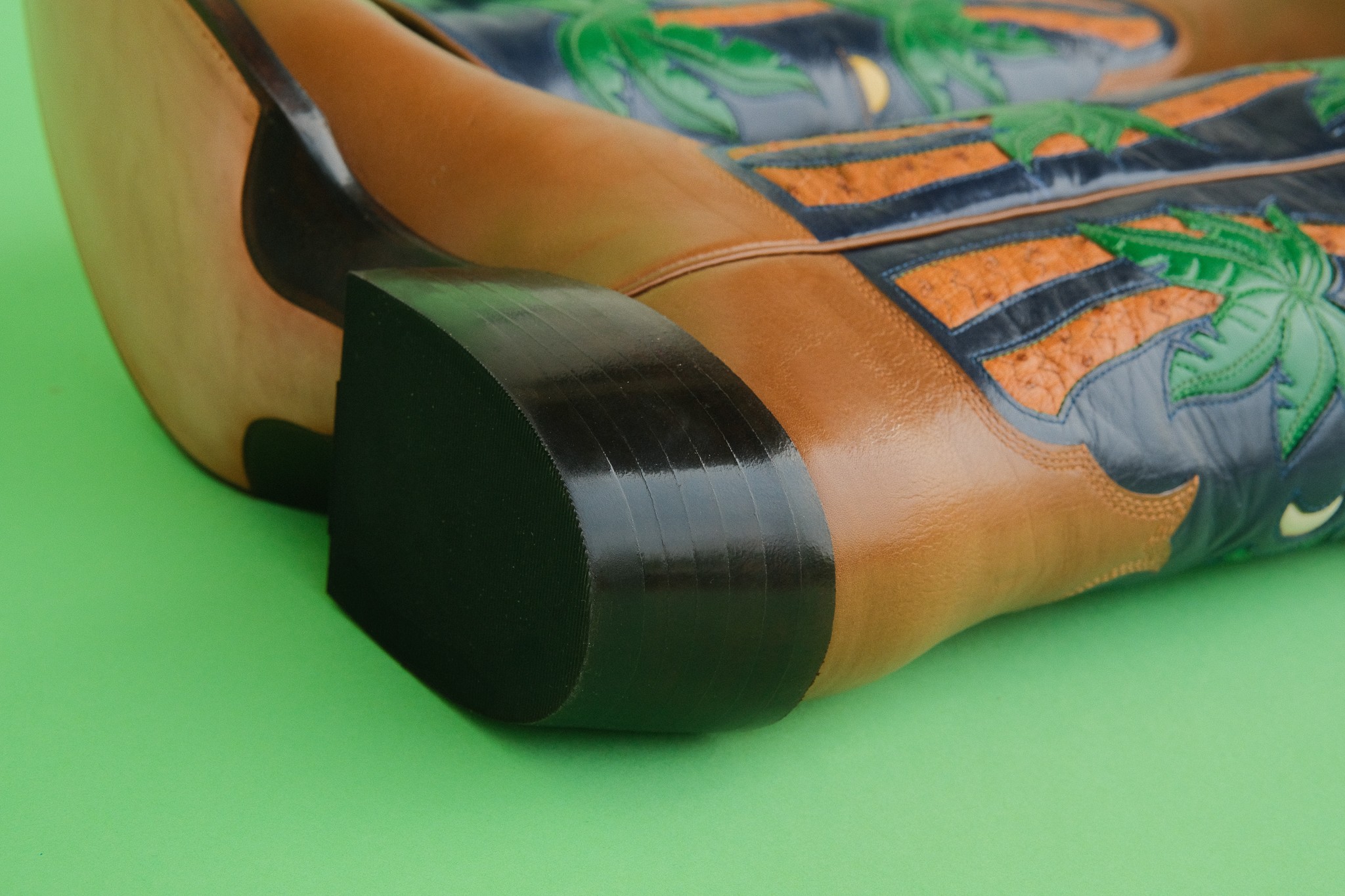 Close-up of an inflatable pool float with a tropical design, resting on a green surface.