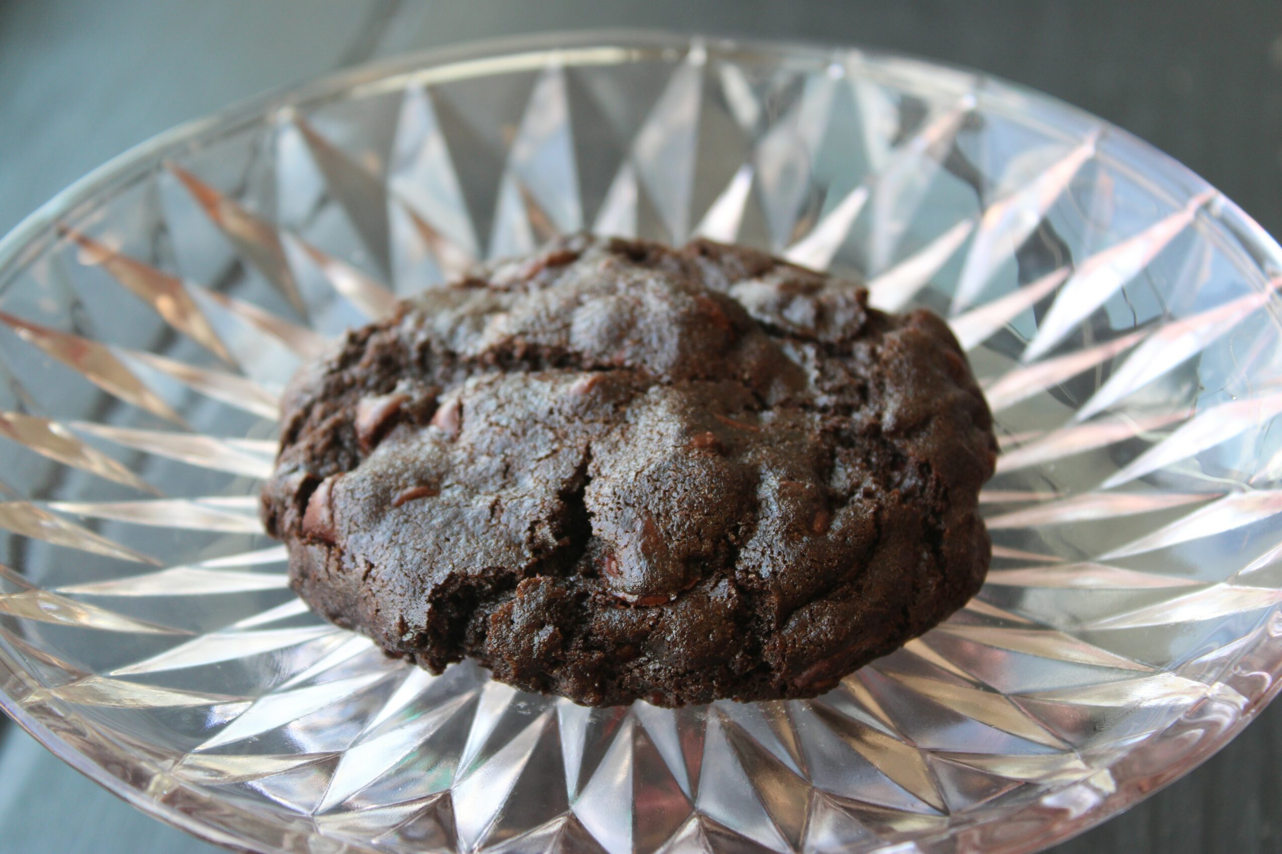 Chocolate cookie on a decorative glass plate with a geometric pattern