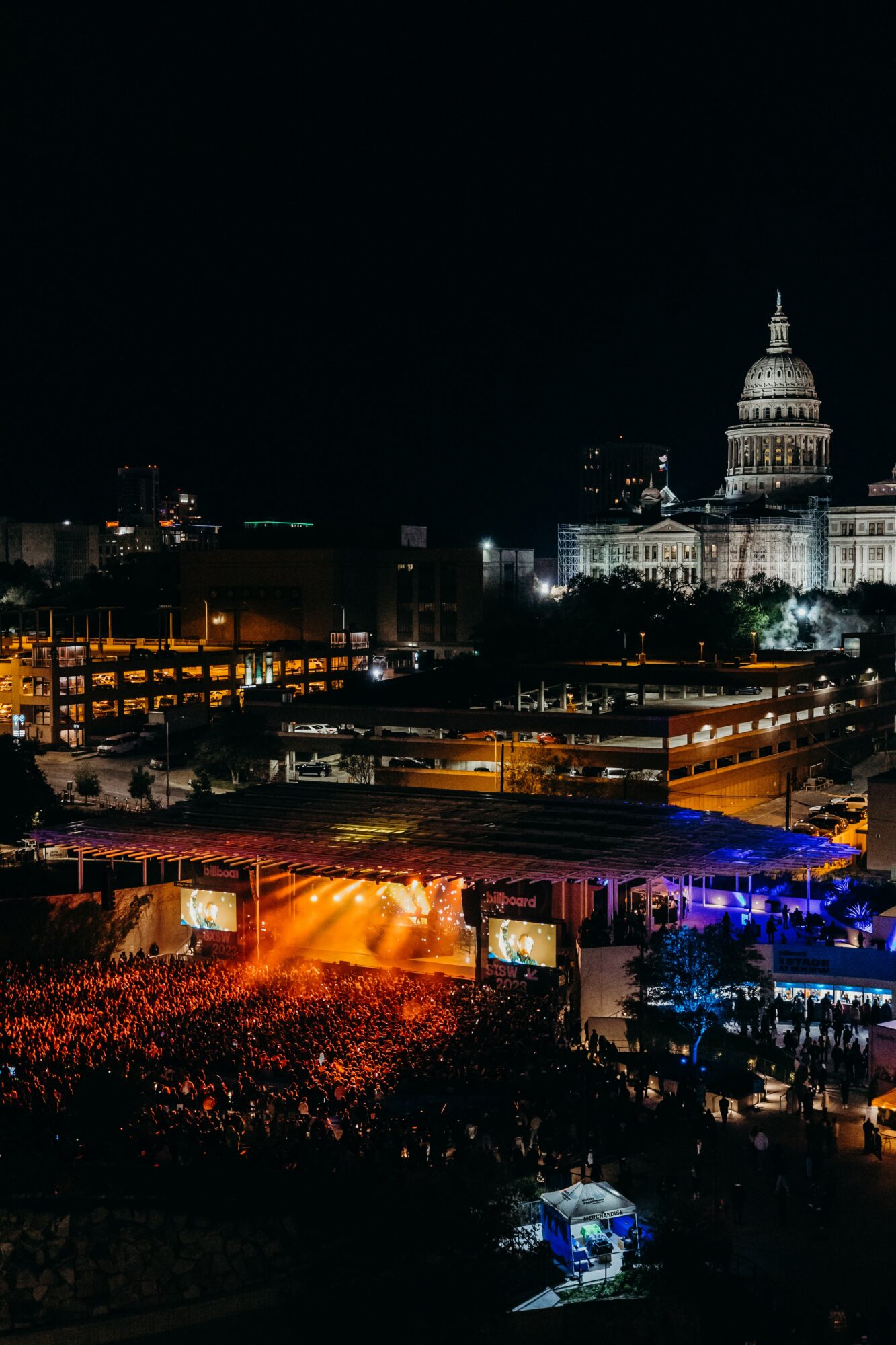 Nighttime cityscape with illuminated buildings and a prominent domed government building in the background.