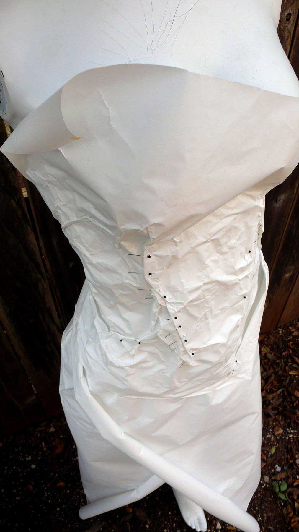 A large white paper bag or wrapping paper draped over a chair, with some wrinkles and holes visible.