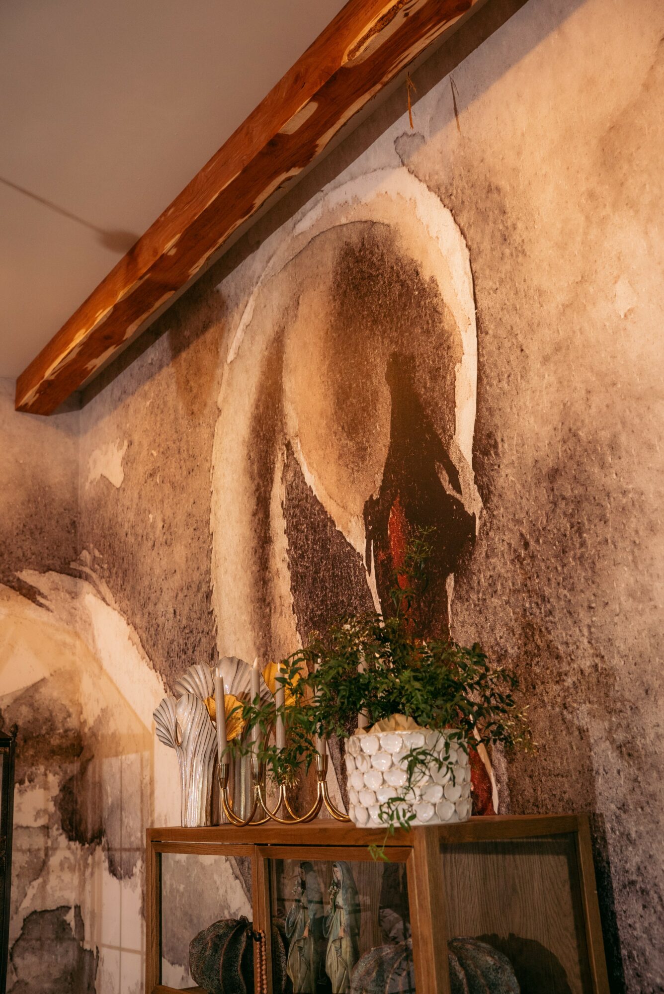 Wall mural of a swan with a plant in front, wooden shelf, and beige textured wall.