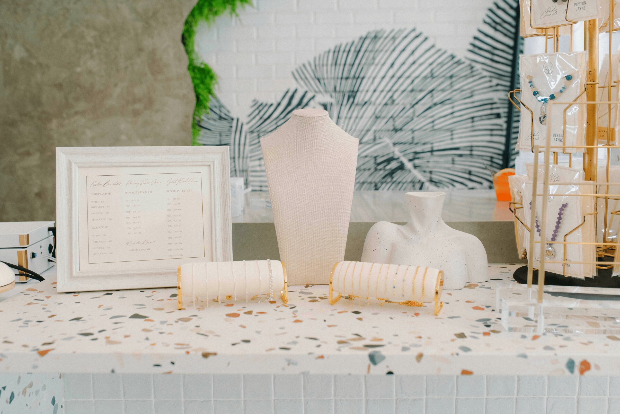 Decorative table with framed document, vase, and art piece, with various objects and a textured background behind.
