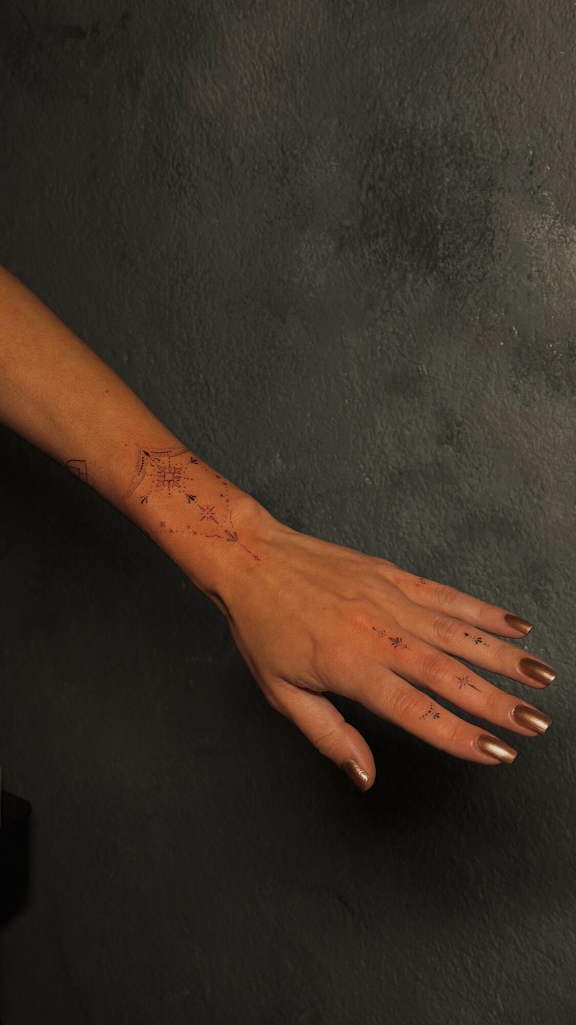 Outstretched hand with visible scars on the arm, resting on a dark surface.