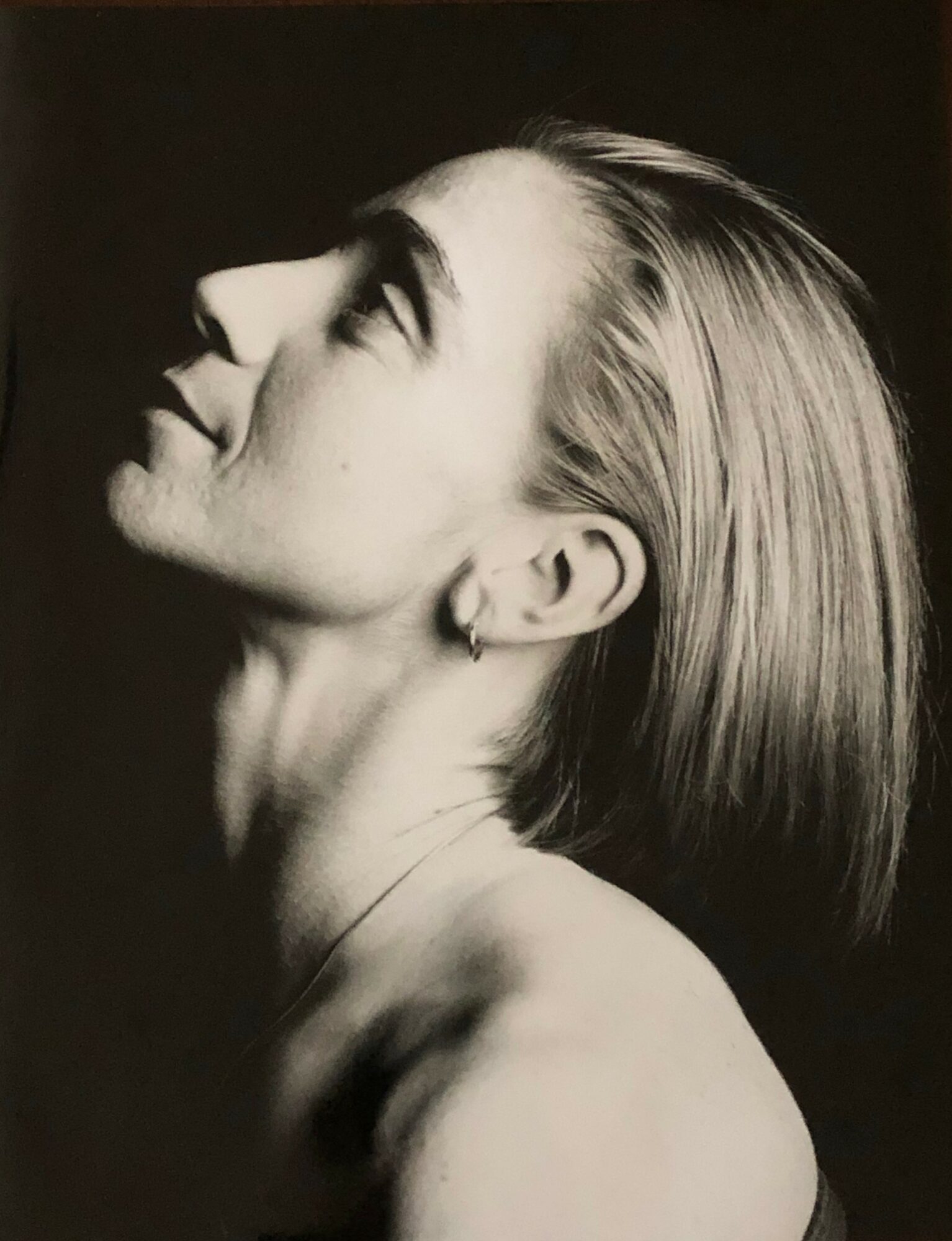Profile of a woman with short hair, looking upward, in black and white.