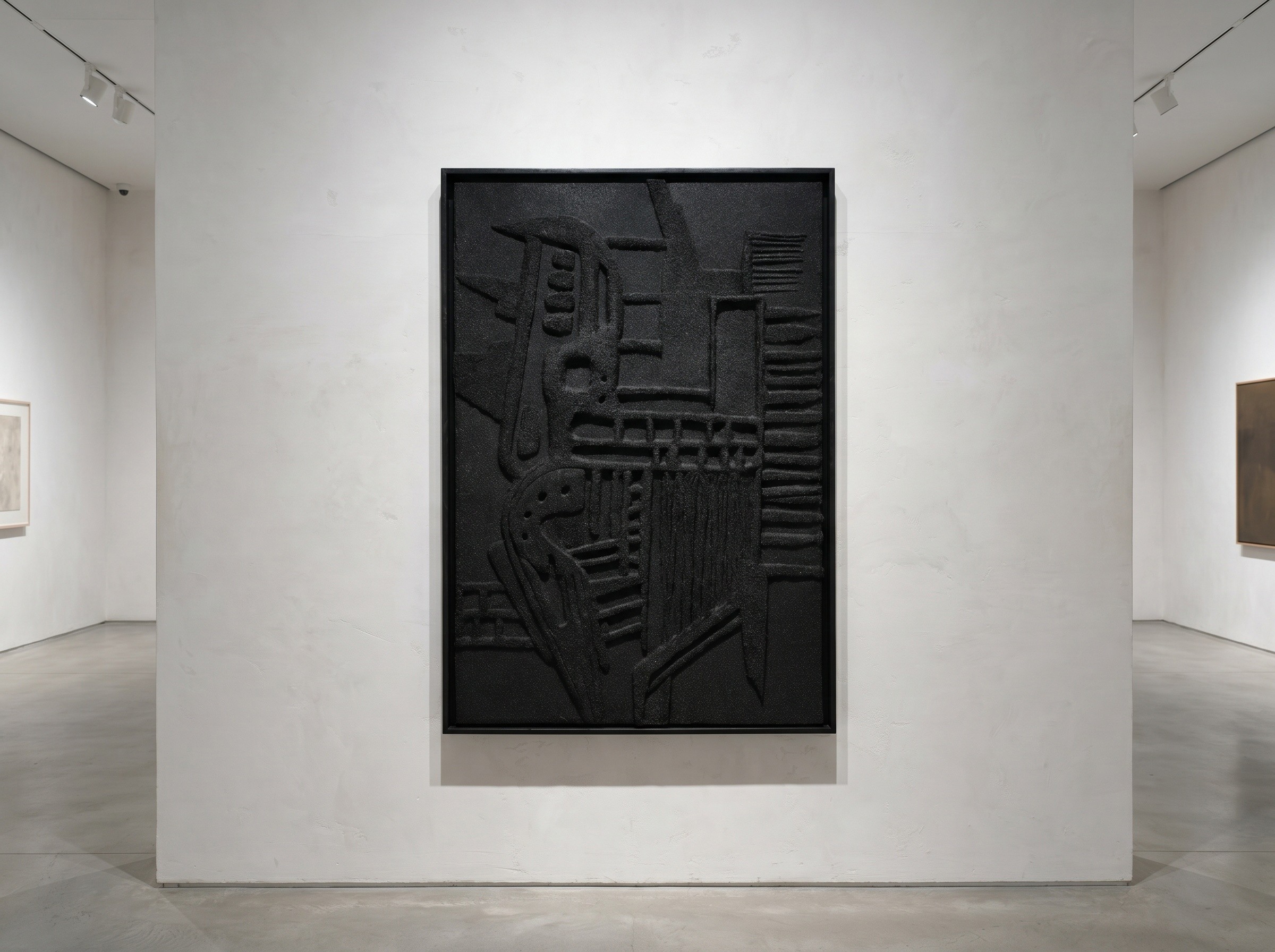 Black textured artwork on a white gallery wall, with other artworks visible in the background.