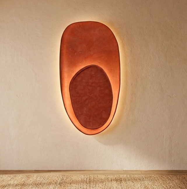 Wall-mounted light fixture with an oval shape and warm glow, on a plain wall.
