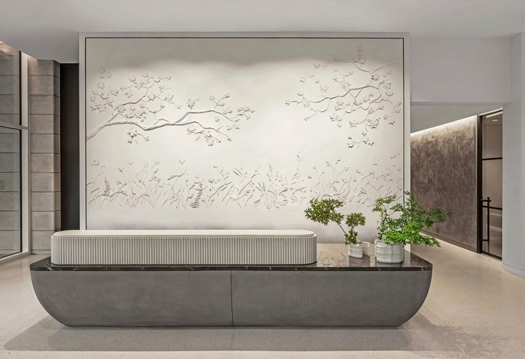 Modern interior with a large decorative wall panel, a bench, and potted plants, in a spacious, minimalist setting.
