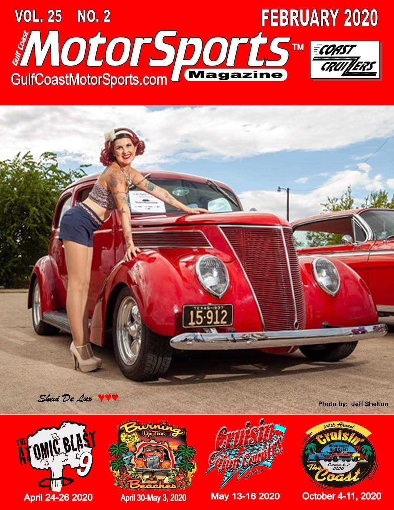 Woman in vintage clothing leaning on a red classic car outdoors, with trees and sky in background.