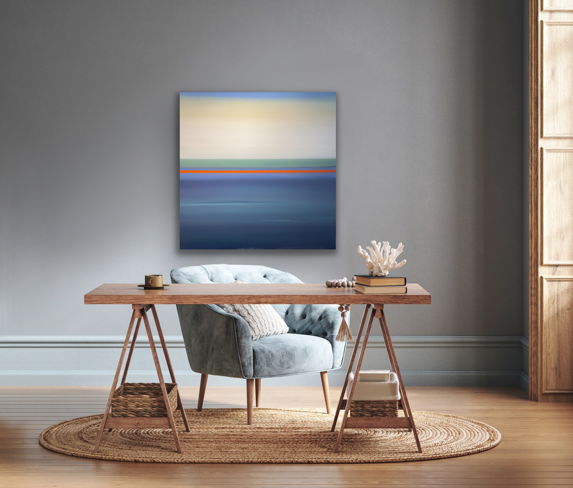 A cozy workspace with a wooden desk, a gray upholstered chair, and a painting on a gray wall.