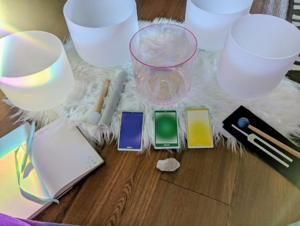 Colorful candles, a book, and a box of matches on a wooden table with a white furry cloth.