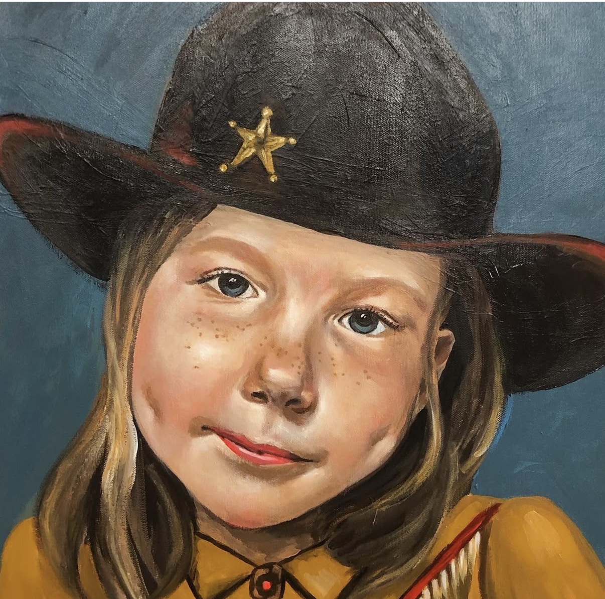 Portrait of a young girl wearing a black hat with a star, smiling, with long hair and a yellow shirt.