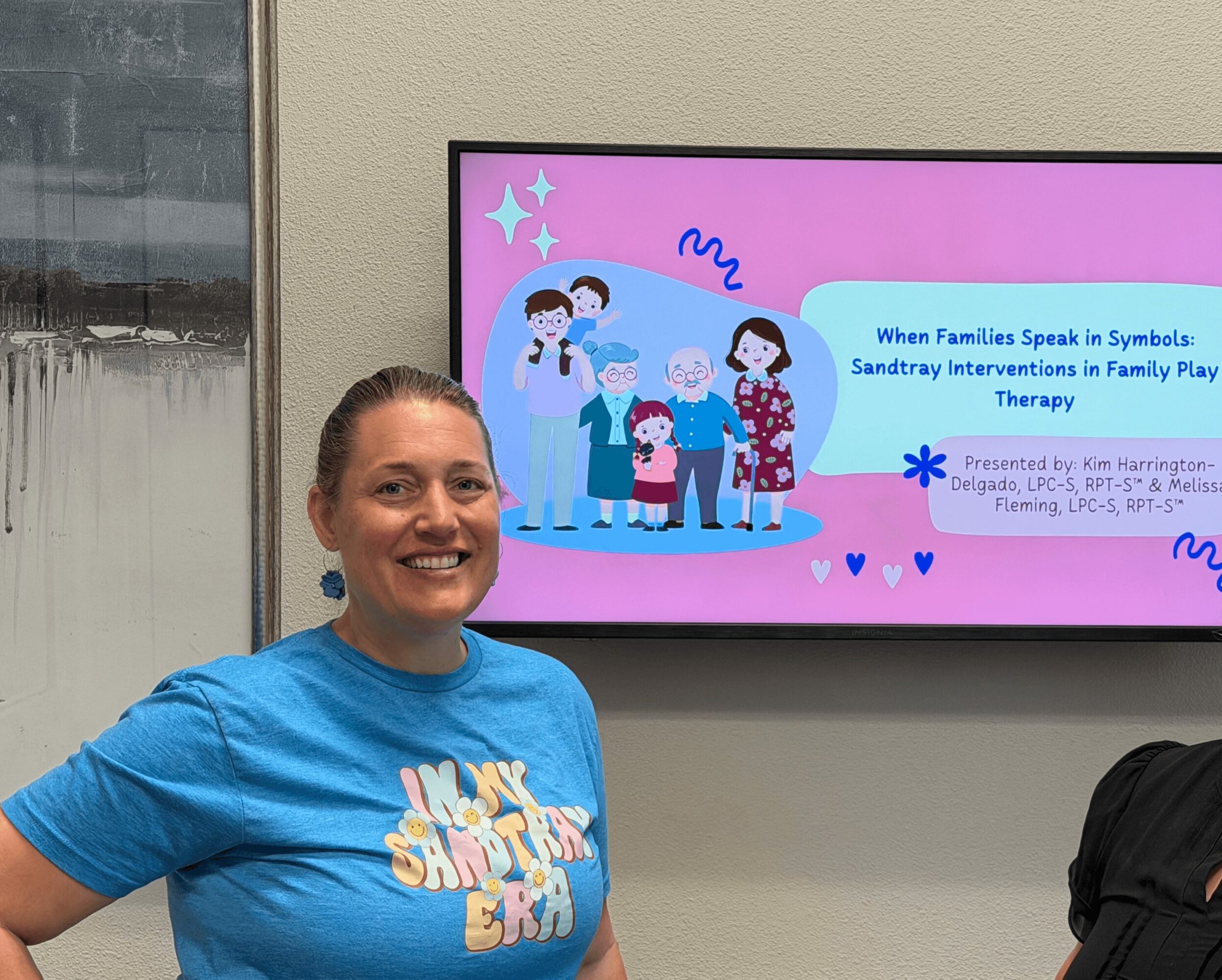 Woman smiling in front of a presentation screen with children and a healthcare professional illustration.