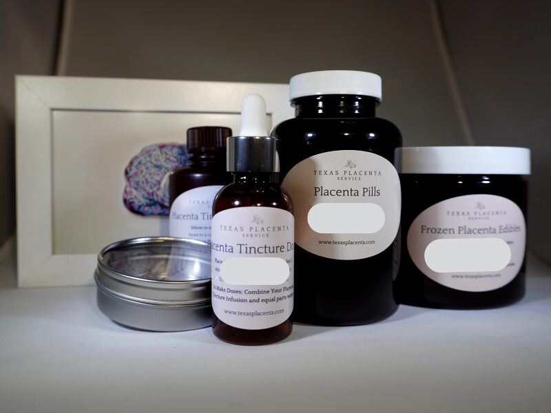 Collection of bottles, jars, and a framed picture on a white surface, with a blurred background.