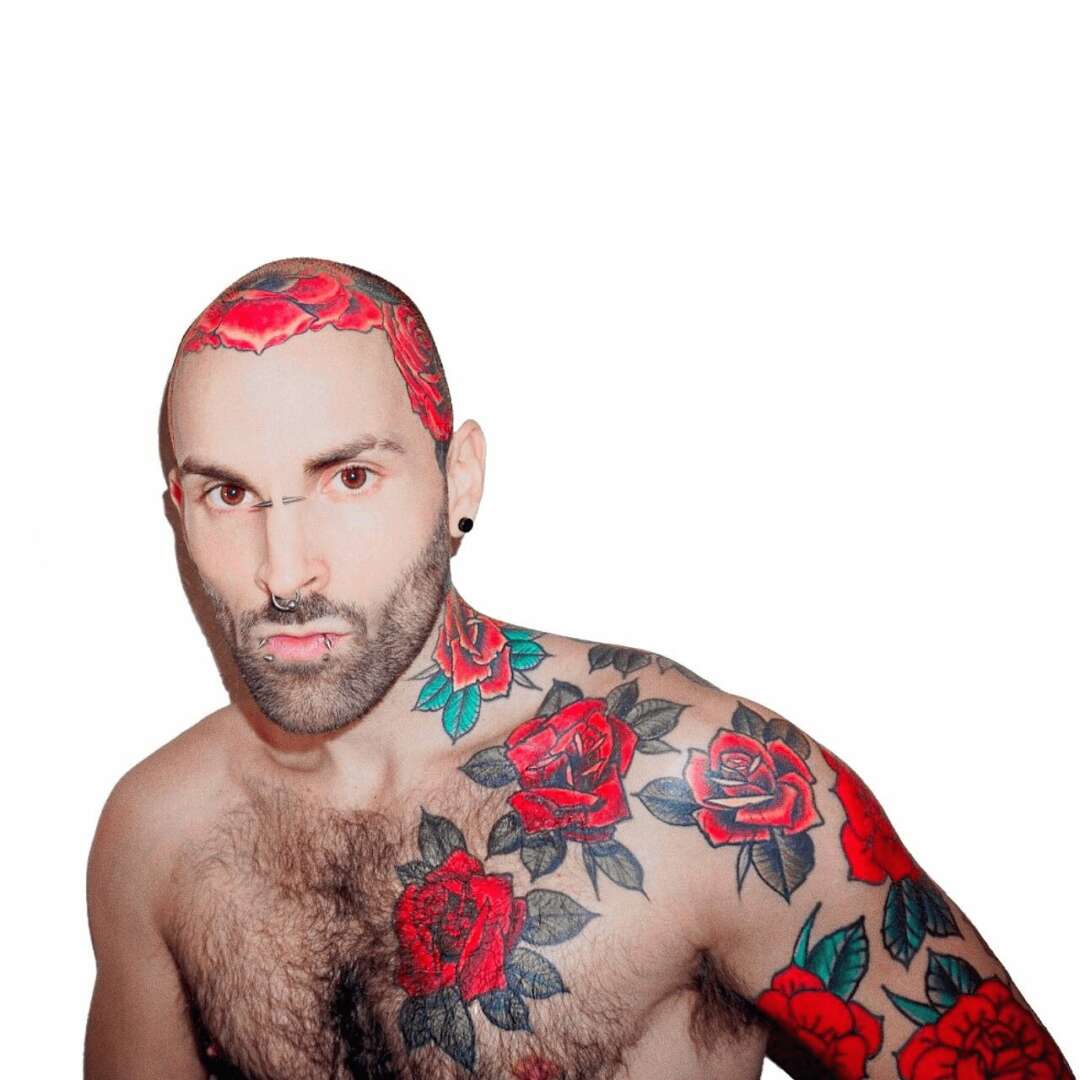 Man with tattoos and red hair, looking at camera, bare chest, white background.