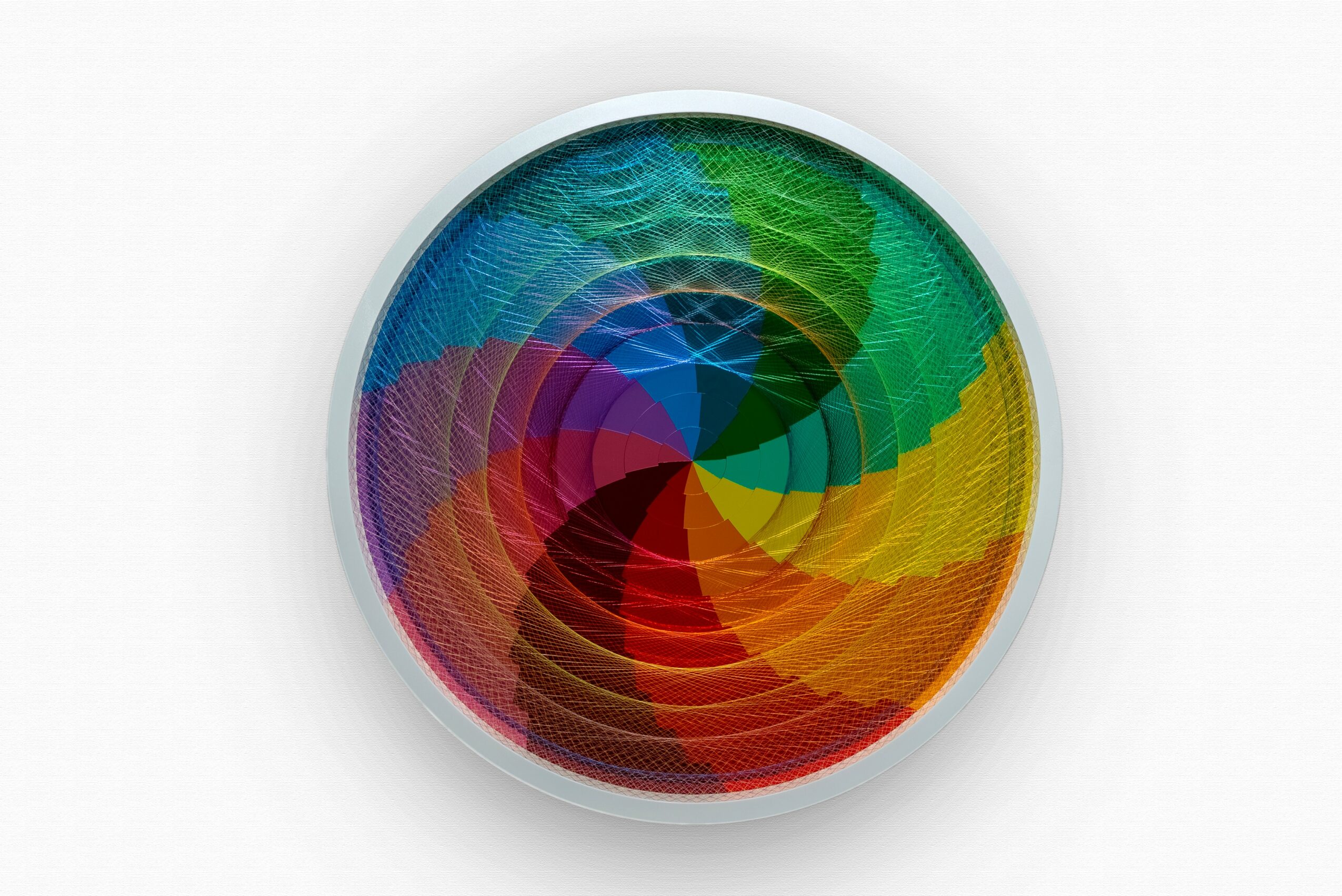 Colorful circular pattern with overlapping rainbow-colored segments, creating a spiral effect, on a white background.