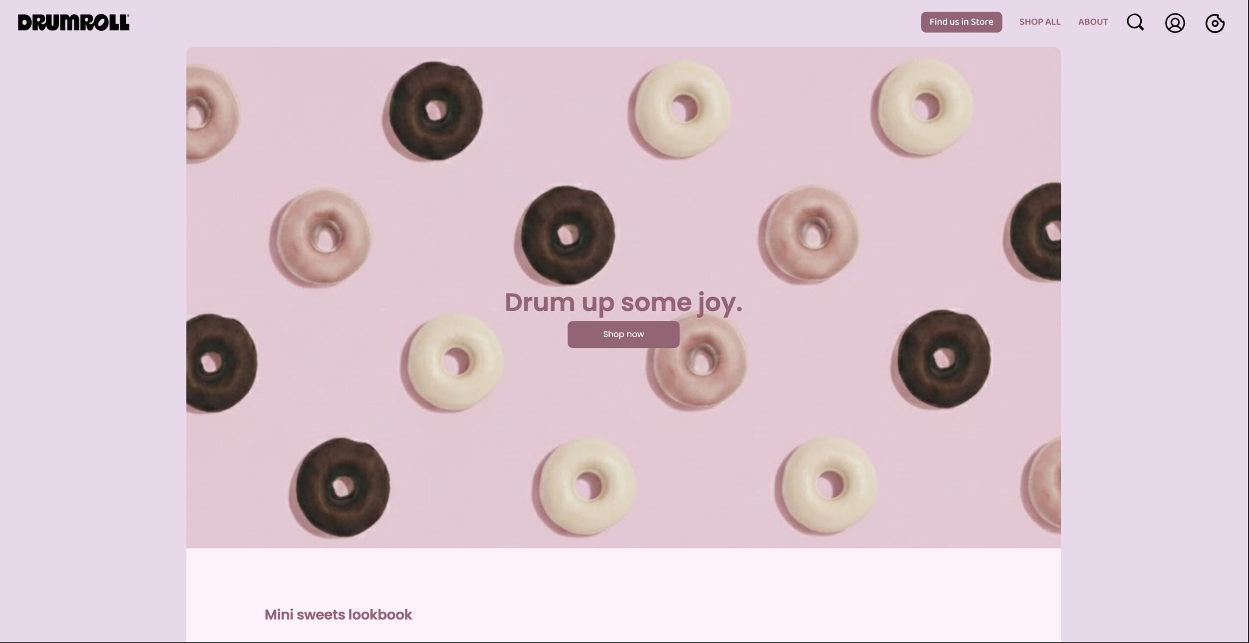 Website homepage with a pink background and scattered donuts in various colors, with text in the center reading 'Drum up some joy.'