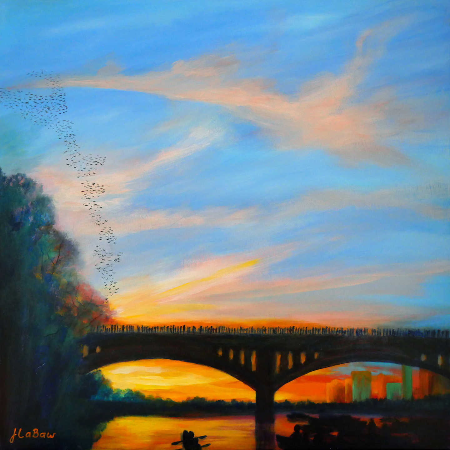 Sunset over a bridge with colorful sky and reflections on water, trees on the left, city buildings in the distance.