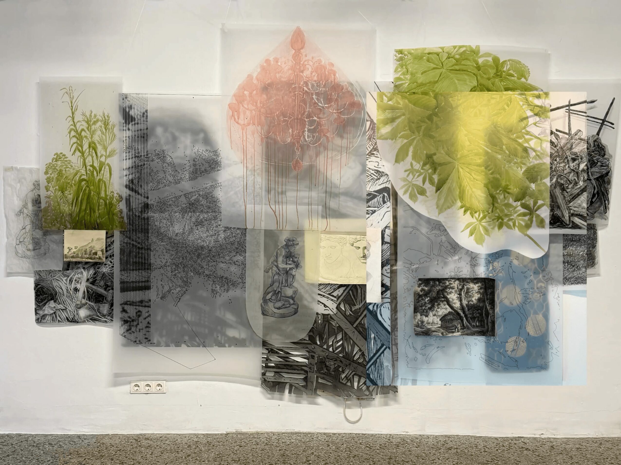 Mixed media artwork with layered transparent papers, plants, and abstract shapes on a white wall, with some notes attached.