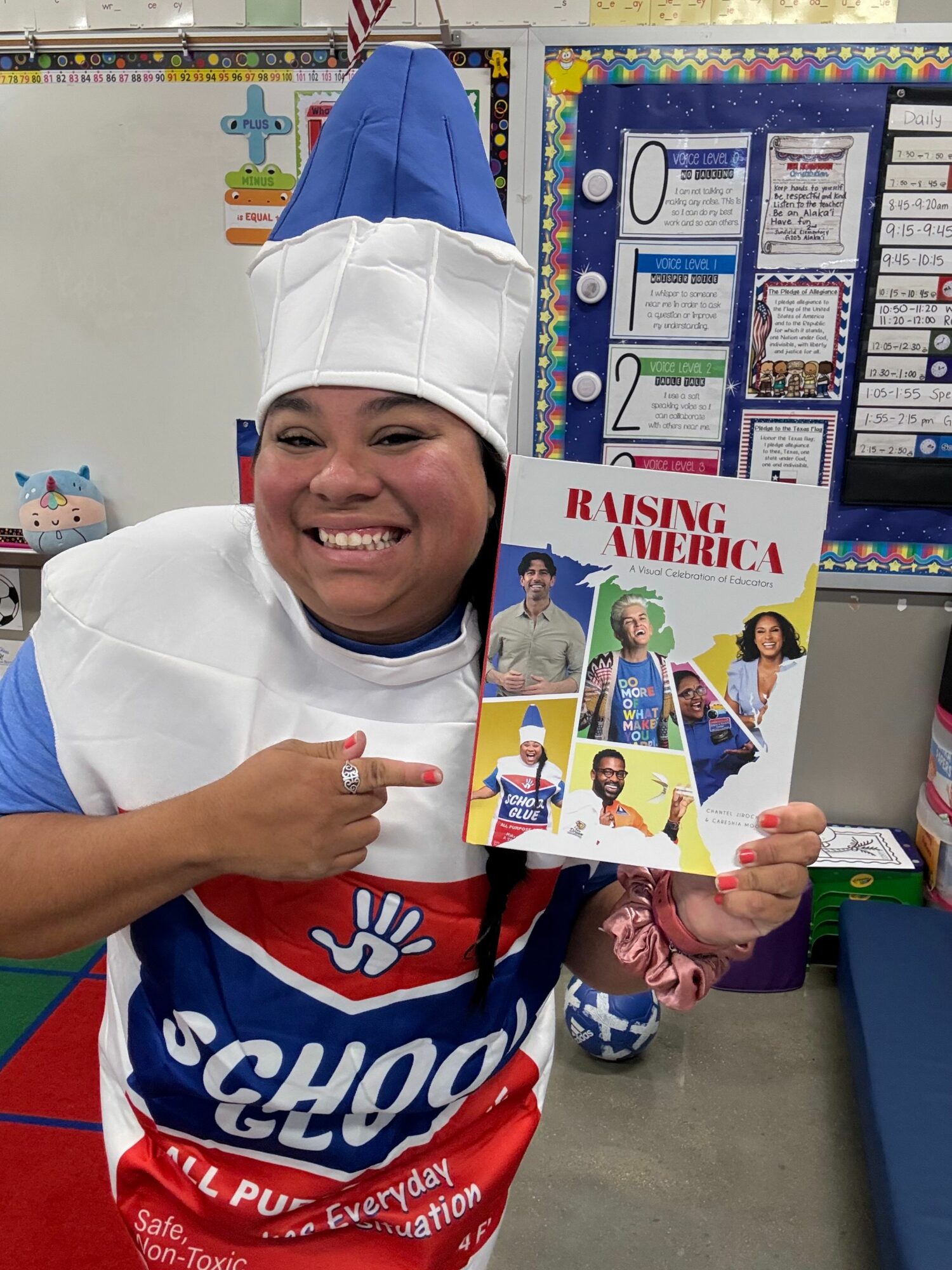 Person dressed as a chef holding a comic book, smiling, in a classroom setting.
