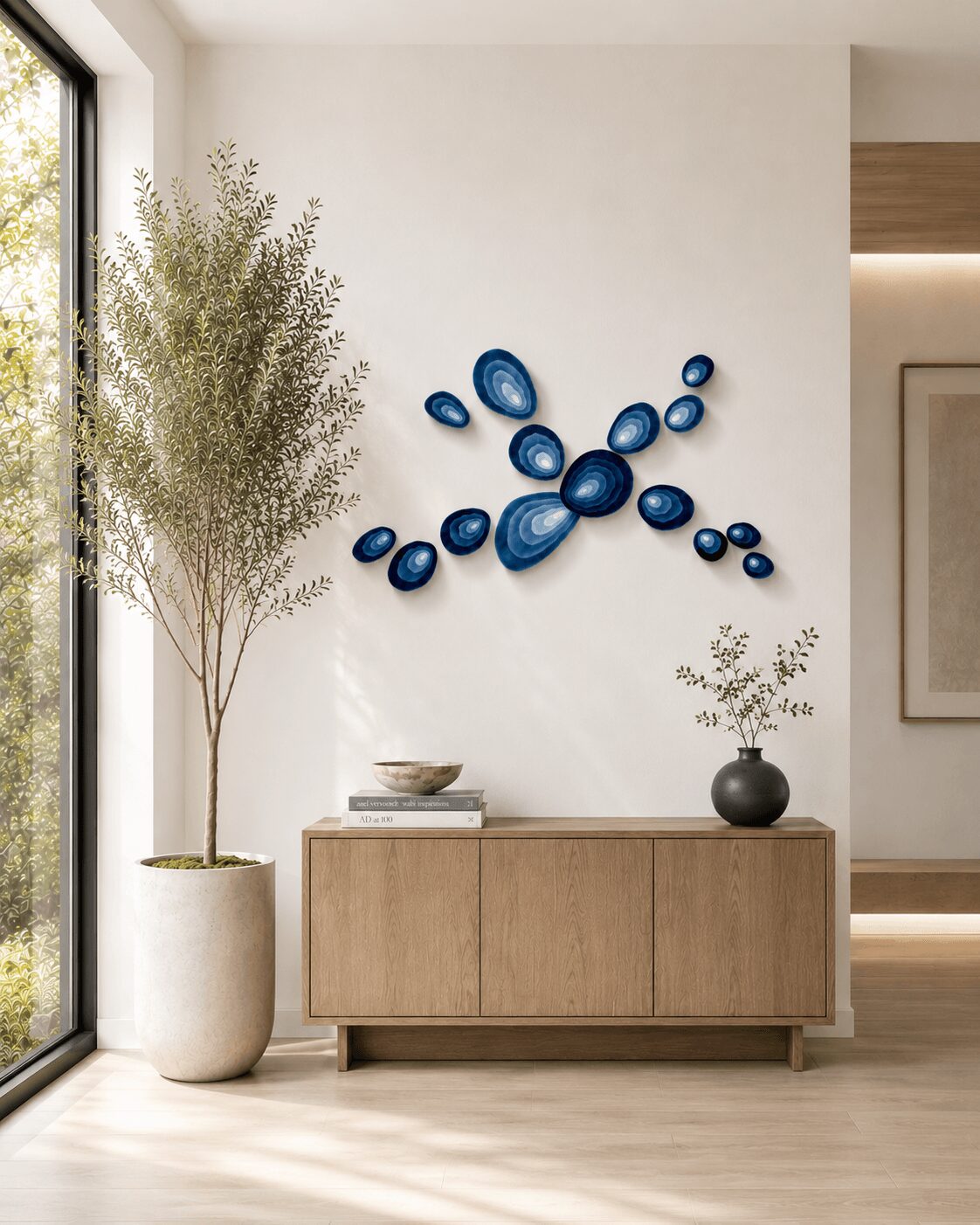 Interior with a wooden sideboard, a large potted plant, and blue wall art, near a window with natural light.