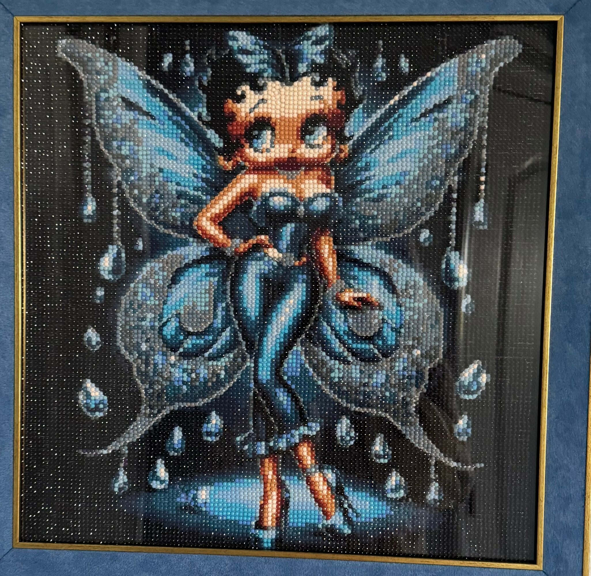 Pixel art of a fairy with blue wings, sitting with legs crossed, surrounded by water droplets, on a dark background.