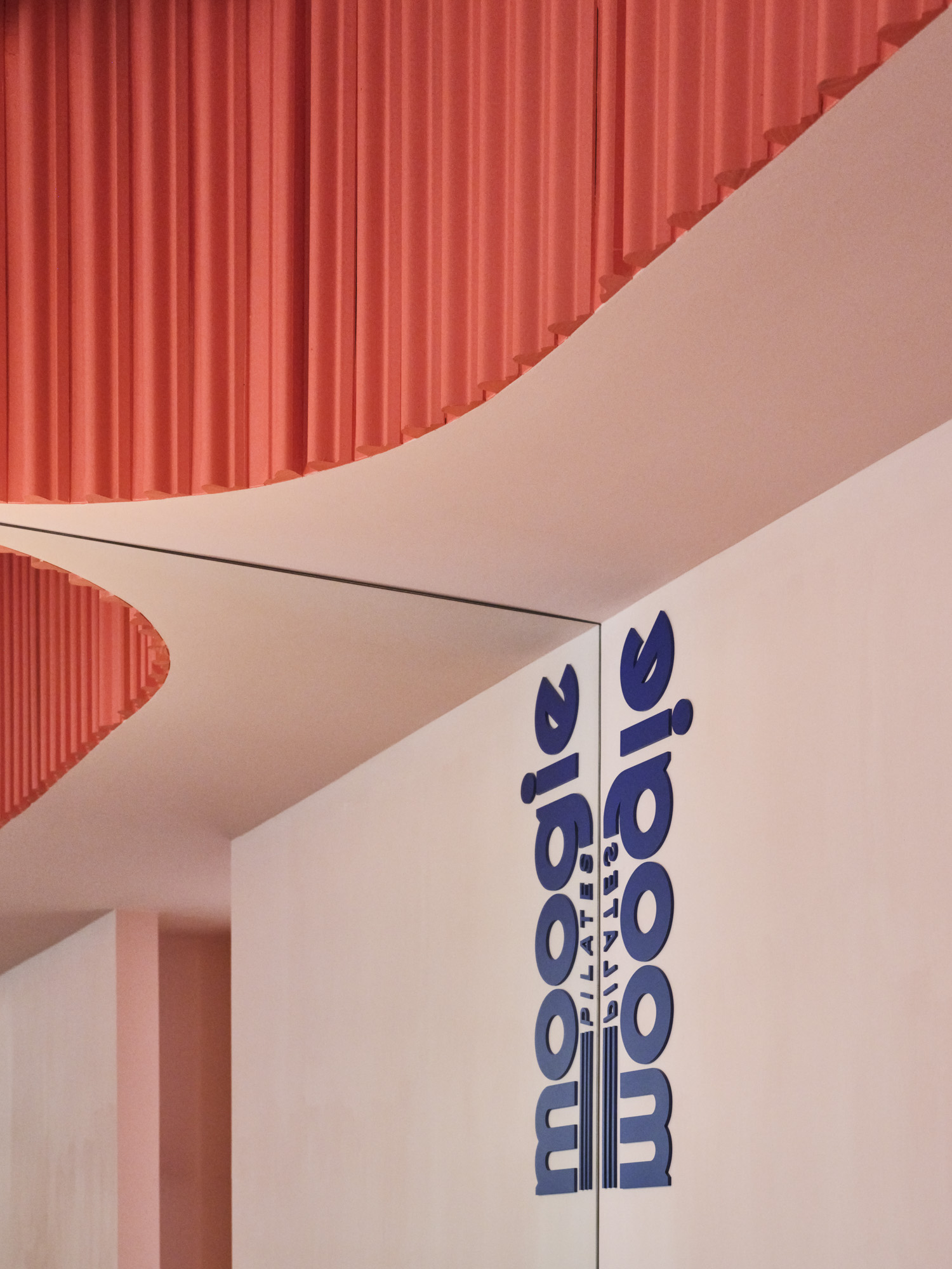 Ceiling with red textured panels and a white wall with blue text, viewed from below, rotated 90 degrees clockwise.