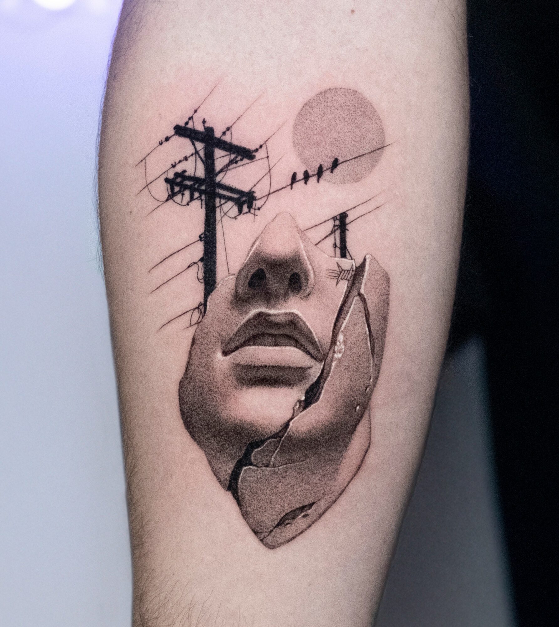 Tattoo of a woman's face with a hand holding a cigarette, telephone pole, and sun in the background.