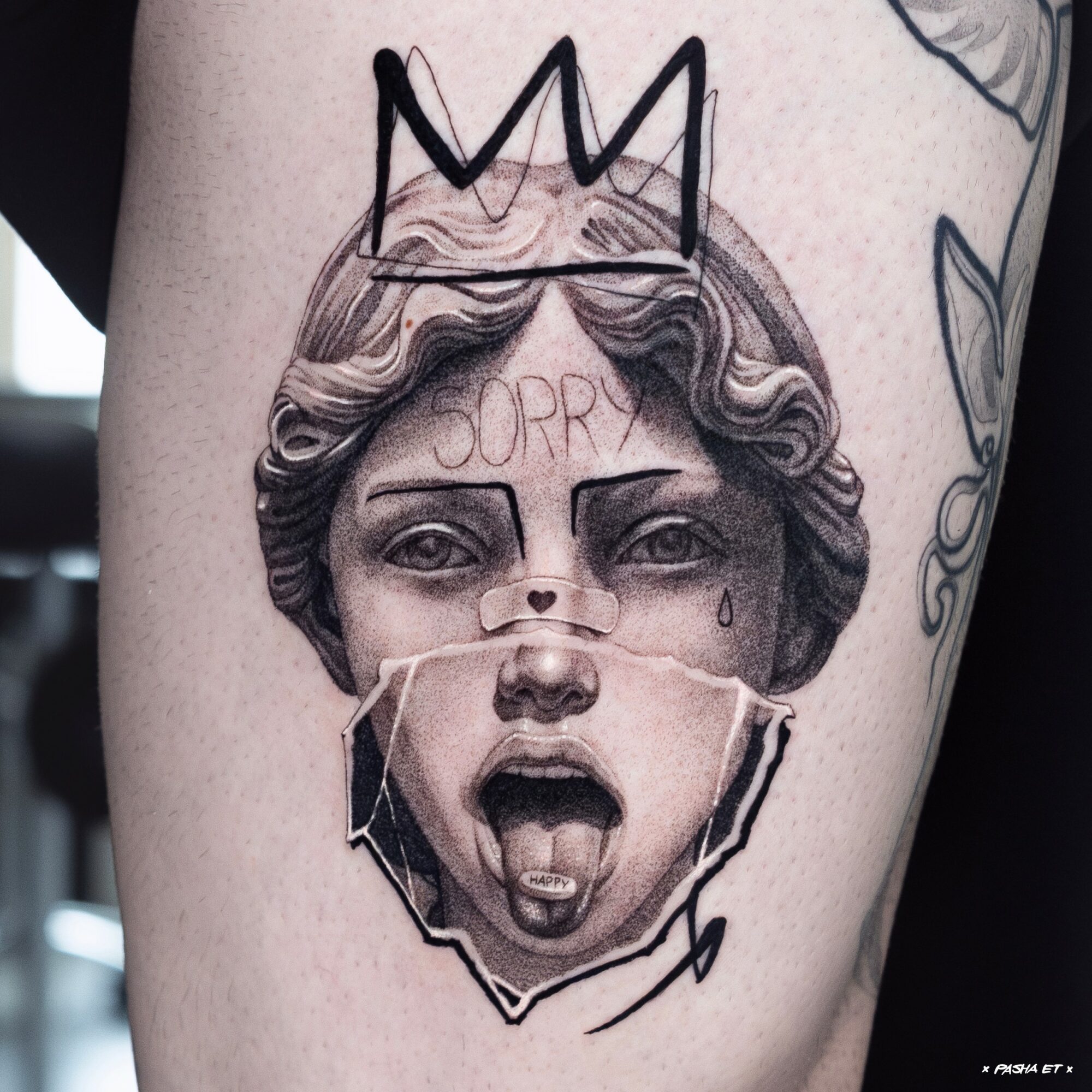 Tattoo of a woman's face with a crown, showing an open mouth and the word 'SORRY' on her forehead.