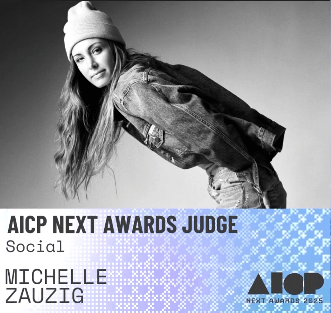 Black and white photo of a woman wearing a beanie and denim jacket, leaning forward. Text: AICP Next Awards Judge, Michelle Zauzig, Social.