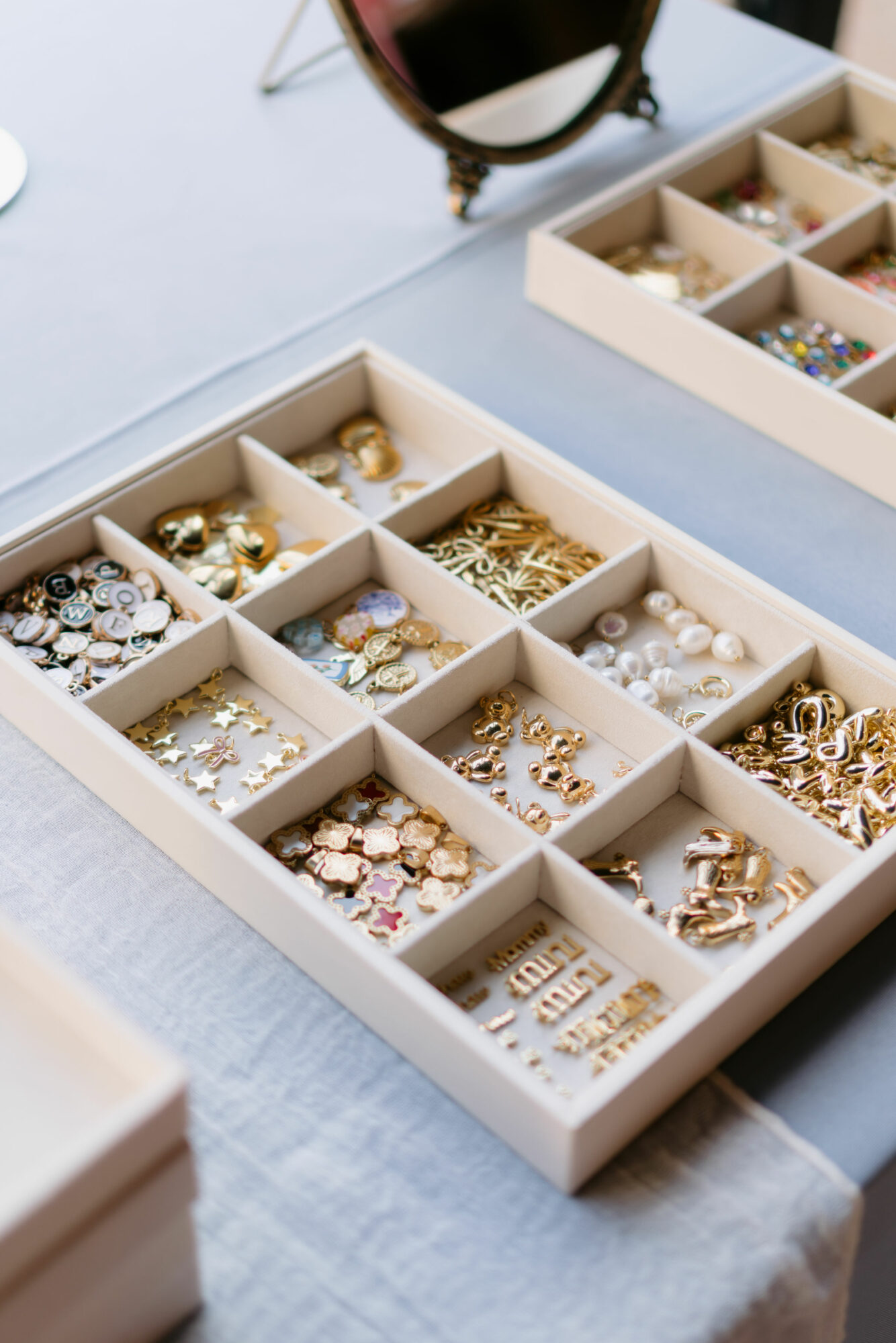 Open jewelry organizer with various earrings, rings, and necklaces on a light-colored surface.