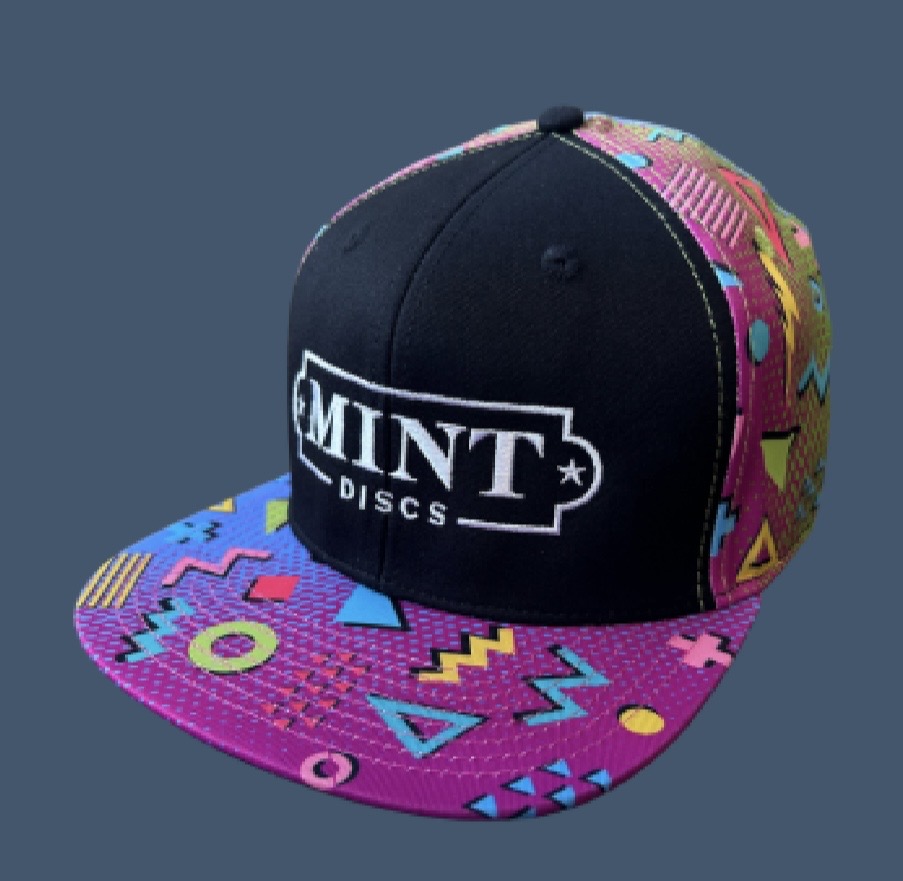 Cap with colorful geometric patterns and a black front panel with white text, on a blue background.