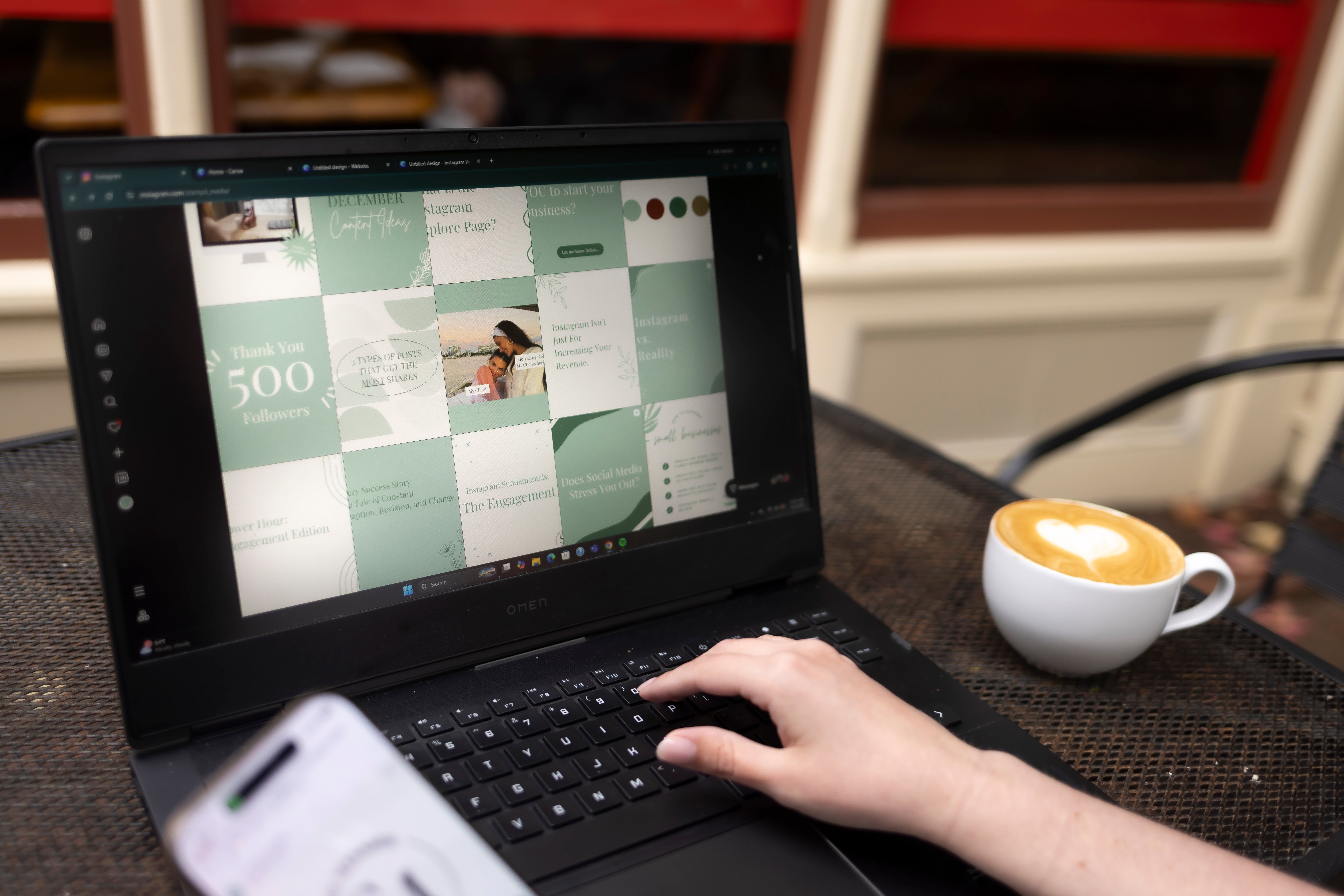 Person's hand using a laptop with a calendar or planner on the screen, on a table with a cup of coffee nearby