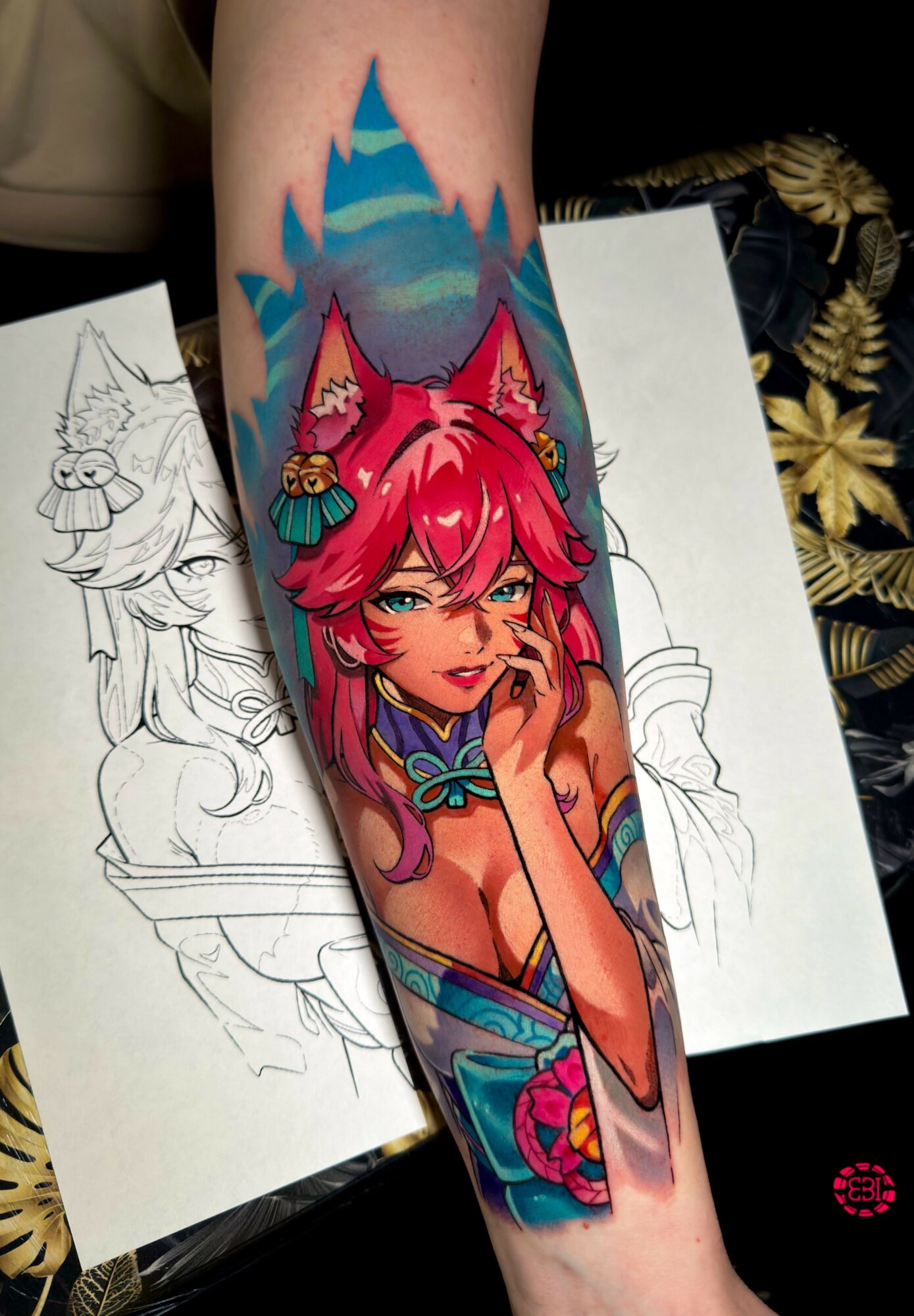 Colorful tattoo of a girl with pink hair and fox ears, with a mountain background, on a person's arm.