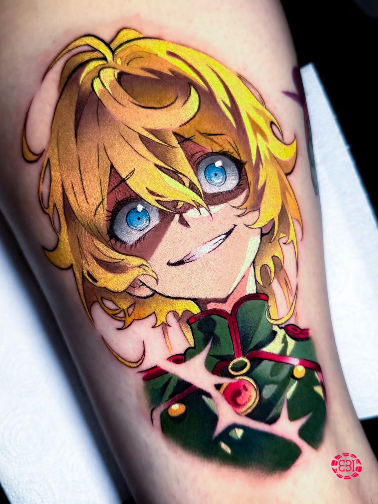 Colorful tattoo of a character with blonde hair and blue eyes, smiling, wearing a green and red outfit, on skin.