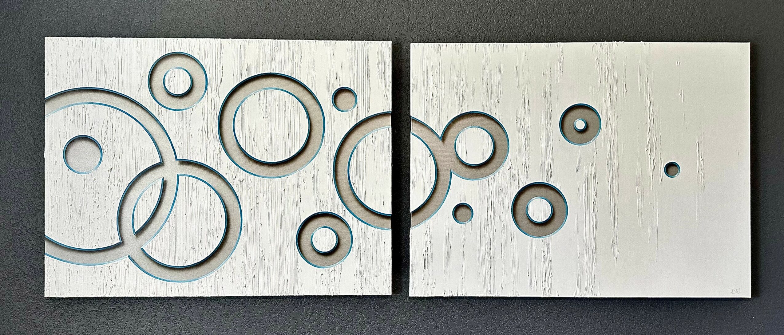 Two rectangular panels with circular cutouts arranged in a pattern, mounted on a wall.